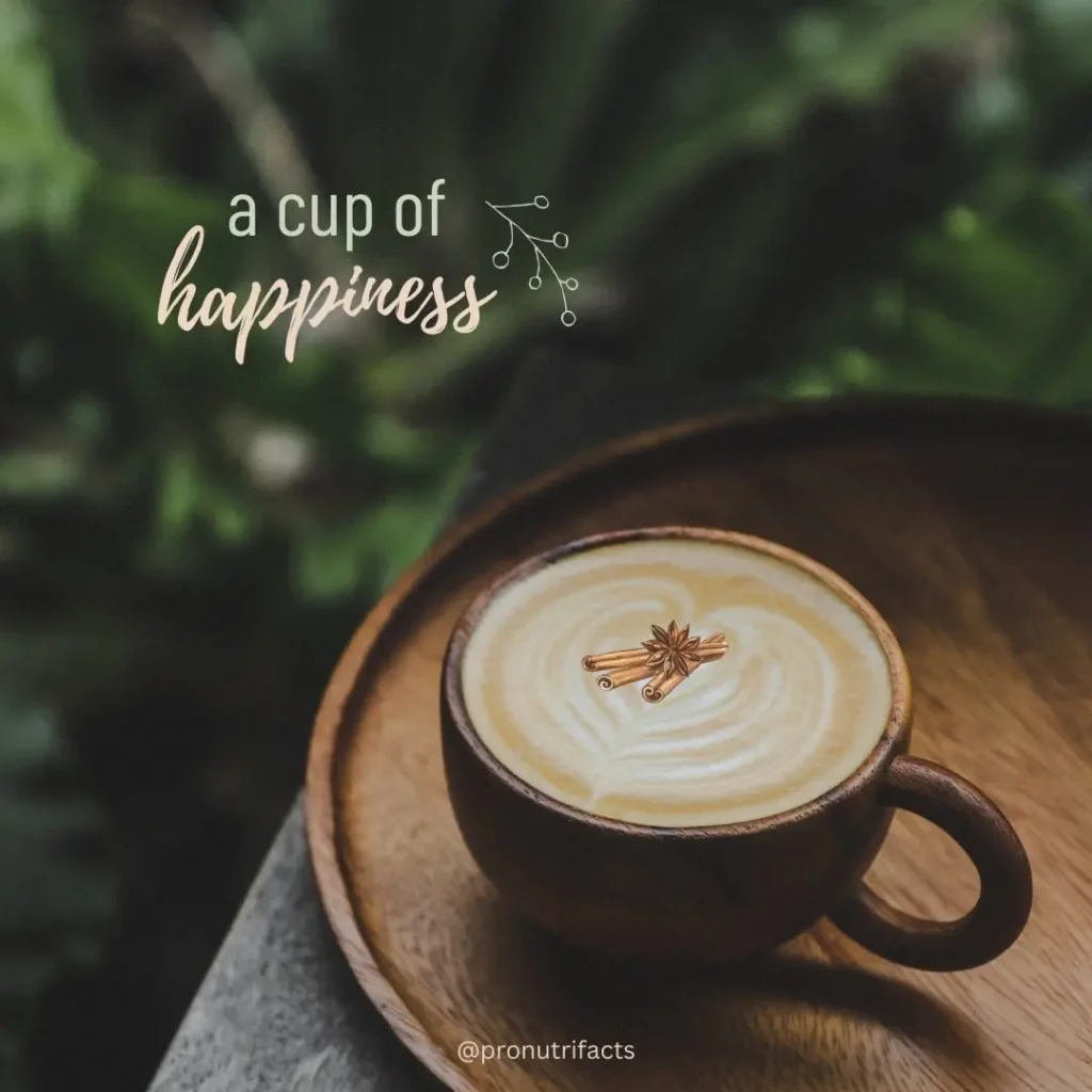 A wooden cup of frothy coffee topped with cinnamon and star anise, placed on a rustic wooden tray with a nature-inspired background. Text overlay says "A cup of happiness.