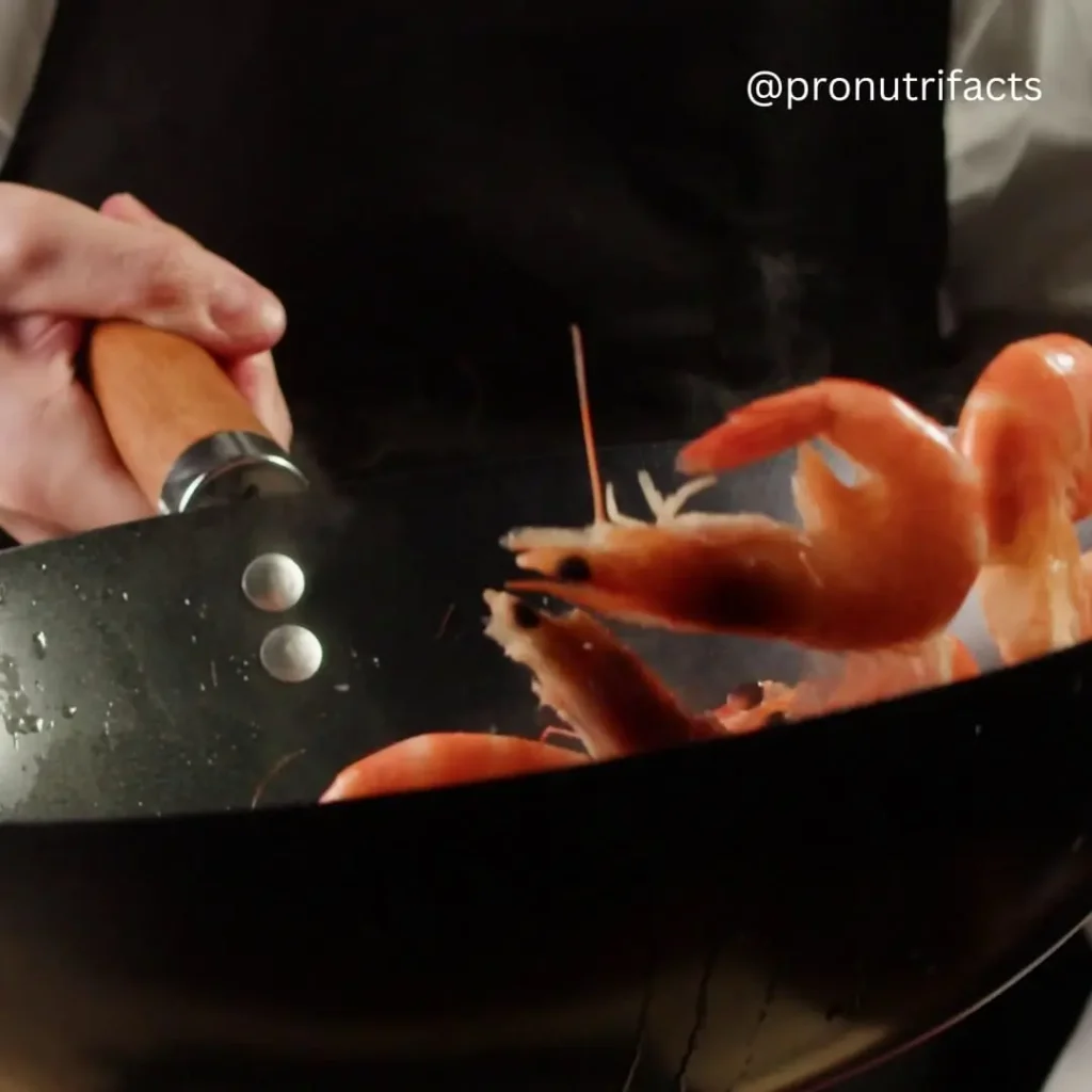 A chef tossing shrimp in a wok, cooking them over high heat, with steam rising from the pan, with the title 'Is Shrimp Good for Weight Loss | Best Ways To Eat' included.