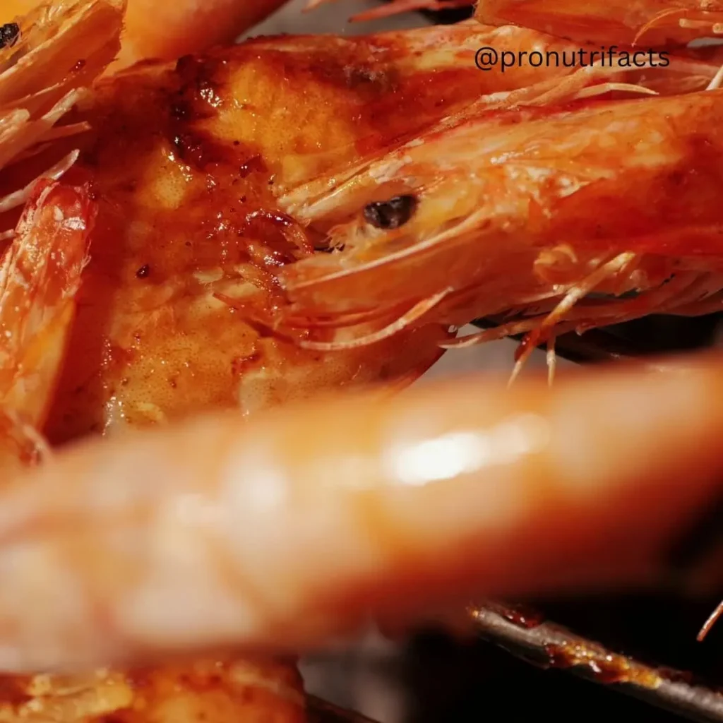 A close-up of grilled shrimp with a golden, crispy texture, glistening with juices and seasoning.